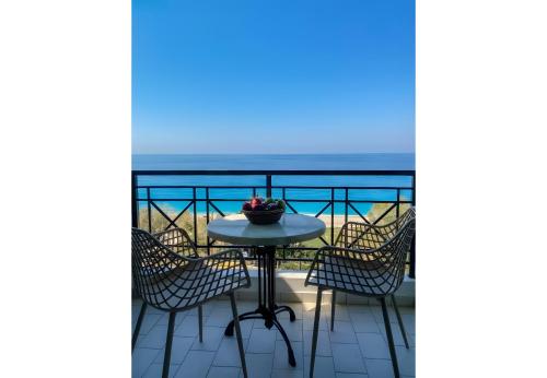 a table and chairs on a balcony with the ocean at Sunset Premium Studio 13 in Agios Nikitas