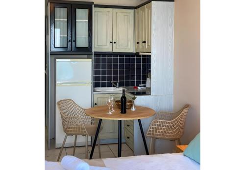 a small kitchen with a table with wine glasses on it at Sunset Premium Studio 13 in Agios Nikitas