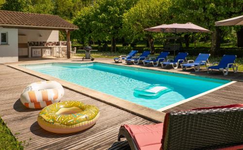 una piscina con sedie e galleggiante accanto di Independent cottage with heated pool a Lempaut