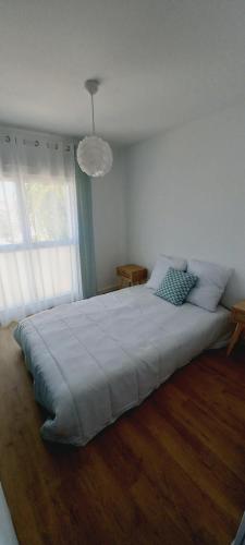 une chambre avec un grand lit avec une grande fenêtre dans l'établissement Bel appartement, grande terrasse côté mer Kerroc'h, à Ploemeur