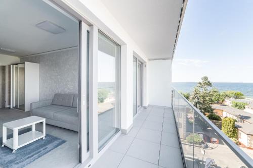 a balcony with a couch and a view of the ocean at Balticus Apartamenty Standard Promenada Gwiazd 14 in Międzyzdroje