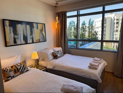 two beds in a room with a window at Haut standing beach apartment in Tangier