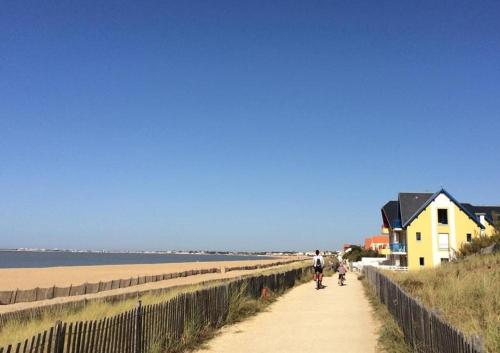 2 personnes marchant sur un chemin à côté de la plage dans l'établissement Appt Studio CHATELAILLON PLAGE - CL060-023, à Châtelaillon-Plage