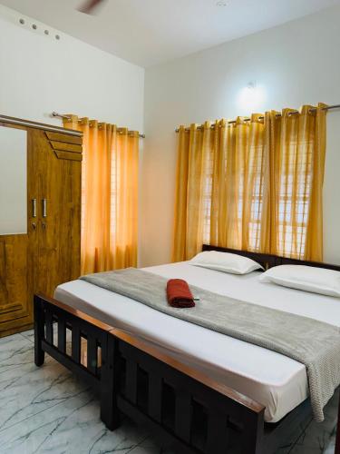a bedroom with two beds and a red hat on the bed at MOON 3bhk ENTIRE VILLA 02 Varkala with kitchen in Varkala