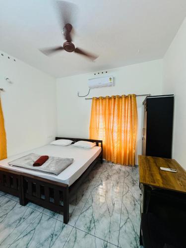 a bedroom with a bed and a ceiling fan at MOON 3bhk ENTIRE VILLA 02 Varkala with kitchen in Varkala