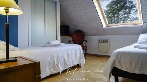 une chambre avec deux lits et une fenêtre dans l'établissement La VILLA DU CABELLOU, à Concarneau