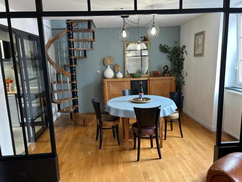 a dining room with a table and chairs and a staircase at L'Ancrage in Saint Malo