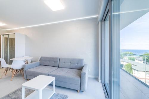 a living room with a couch and a table at Balticus Apartamenty Standard Promenada Gwiazd 14 in Międzyzdroje