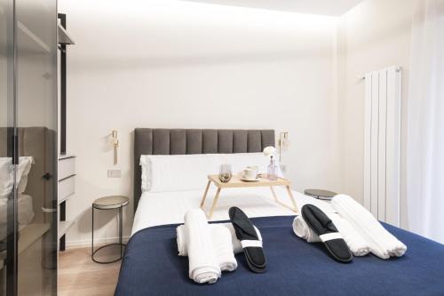 a bedroom with a bed with towels and a table at Easylife - Duomo Deluxe Apartments #5-11 in Milan