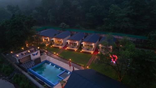 an aerial view of a house with a swimming pool at Mountain Woods Farm Stay in Khopoli