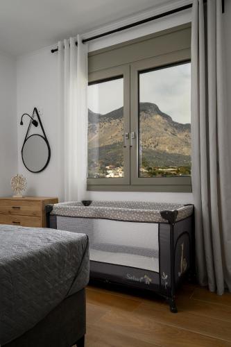 a bedroom with a window with a view of a mountain at Zaros Springs Villa Thea in Zarós