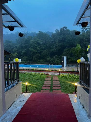 a red carpeted walkway leading to a swimming pool at Mountain Woods Farm Stay in Khopoli