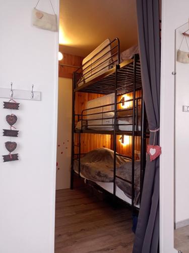 une chambre avec deux lits superposés dans une pièce dans l'établissement Appartement hyper centre ville,5pers 'le maloudgja' vue sur le sancy, à Le Mont-Dore