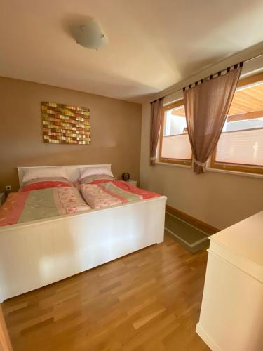 a bedroom with a white bed and a window at Haus Zimba Ferienwohnung am Bartholomäberg in Bartholomäberg