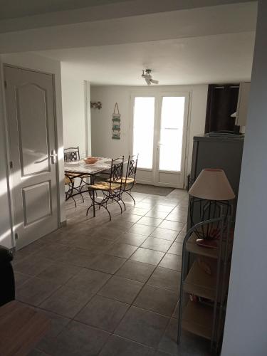 a kitchen and dining room with a table and chairs at Maison de village au calme in Saujon