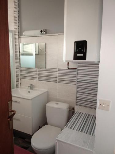 a small bathroom with a toilet and a sink at Maison de village au calme in Saujon