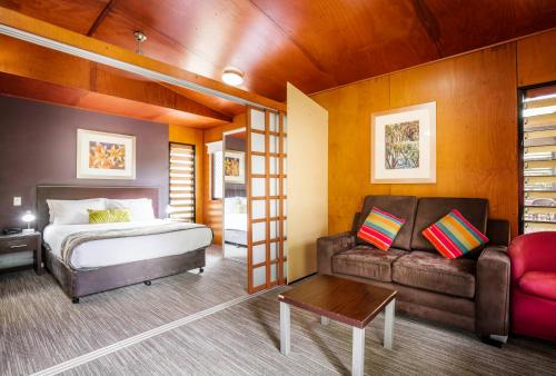 a bedroom with a bed and a couch at Mercure Darwin Airport Resort in Darwin