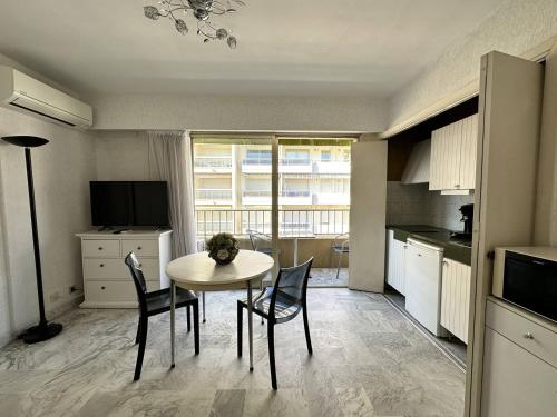 une cuisine avec une table et des chaises dans une pièce dans l'établissement Cannes proche Croisette - Studio, à Cannes