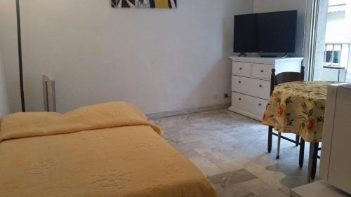 une chambre avec un lit, une table et une télévision dans l'établissement Cannes proche Croisette - Studio, à Cannes