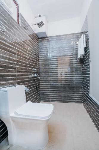 a bathroom with a toilet and a shower at Aachman Nature Valley Resort Mashobra BY NAINA STAYCATION- Private Parking - Balcony and valley view Rooms in Shimla