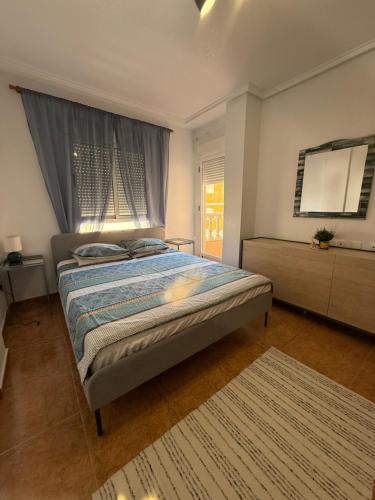 a bedroom with a bed and a large window at Los Molinos in Torrevieja