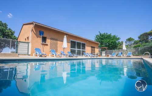 une piscine avec des chaises et un bâtiment dans l'établissement St-Germain - Les Terrasses de l'Ardèche - Piscine, à Salavas
