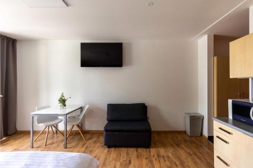 a room with a table and a chair and a tv at Vranovská pláž - Holiday park in Vranov nad Dyjí