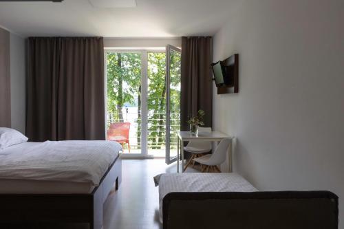 a hotel room with two beds and a desk and a window at Vranovská pláž - Holiday park in Vranov nad Dyjí