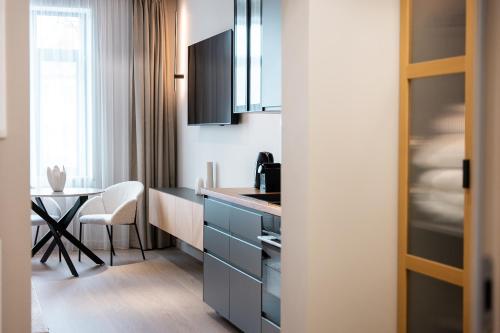 eine Küche mit einem Schreibtisch und einem Tisch mit einem Stuhl in der Unterkunft Memel Town Apartments in Klaipėda