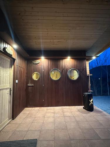 a wooden wall with three circular windows on it at Country Chalet in Praid