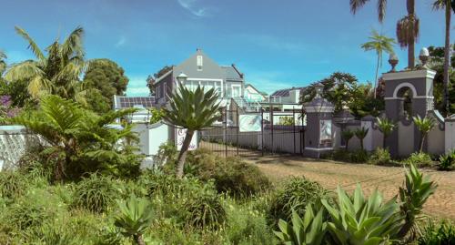una casa con recinzione e palme di Tsitsikamma Mountain View Lodge a Stormsrivier