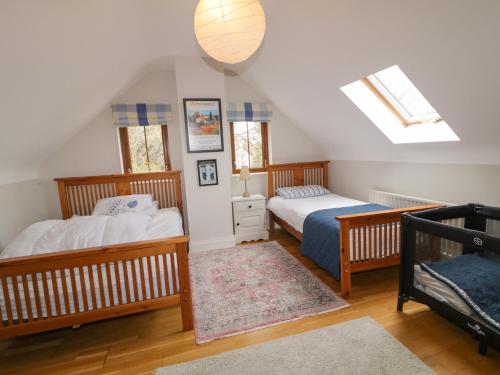 two beds in a attic bedroom with skylights at Clondallon Cottage in Rathmullan