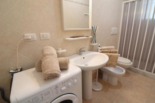 a bathroom with a washing machine and a sink at Casa Asia Otranto Beach & Center AC, WiFi & 4 Sleeps in Otranto