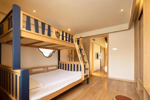a bunk bed in a room with a ladder at 宏村塔川书院Hongcun Resort in Huangshan