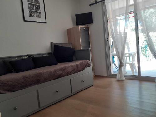 un lit dans une chambre avec une grande fenêtre dans l'établissement 004 Ipanema le Cap'Tif, au Cap d'Agde