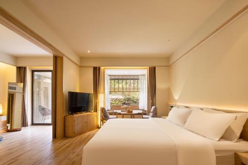 a hotel room with a bed and a television at 宏村塔川书院Hongcun Resort in Huangshan