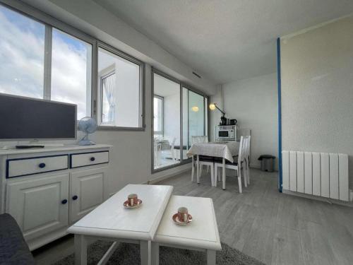 un salon avec une télévision à écran plat et une table dans l'établissement Appartement vue mer - LA ROCHELLE - LR240-505, à La Rochelle