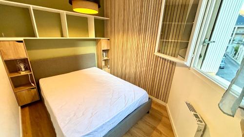 une petite chambre avec un lit et une fenêtre dans l'établissement Chez Yoyo & Mag - T2 en centre ville - Wi-Fi - Parking, à Luchon