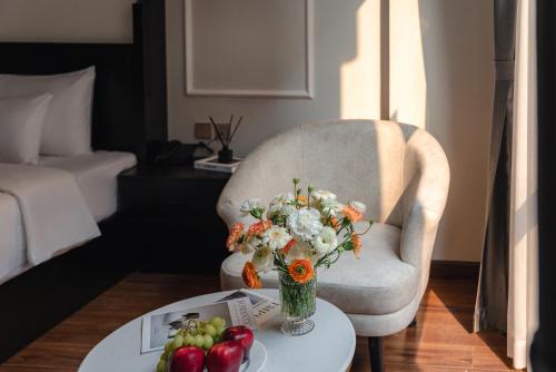 a living room with a chair and a table with a vase of flowers at Cloud 22Land hotel in Hanoi