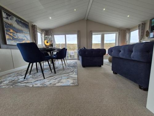 a dining room with a table and chairs and a couch at The Blue Lagoon 2 bedroom lodge with hot tub in Walton-on-the-Naze