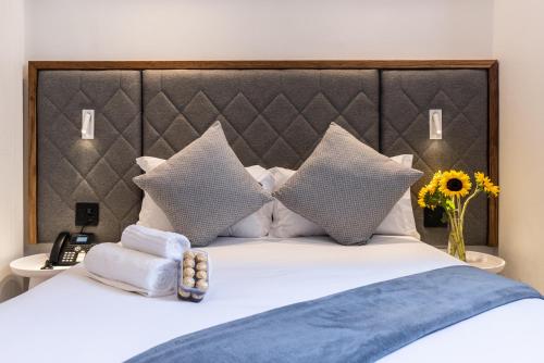 a bedroom with a bed with pillows and a headboard at Cape Diamond Boutique Hotel in Cape Town