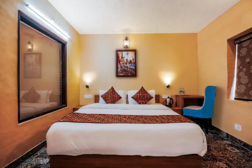 a hotel room with a large bed and a blue chair at Himalayan Mountain and Valley View - Garden with bonefire - Ample Parking - Luxury Balcony rooms -by Aachman Stays!! Mashobra in Shimla