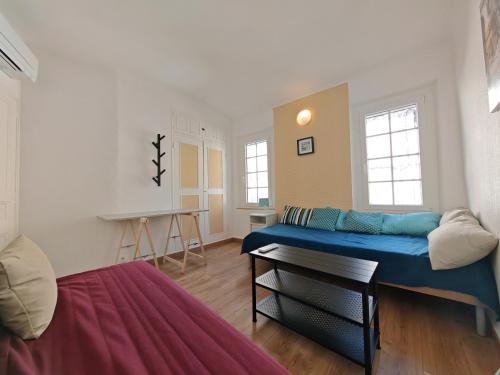 - un salon avec un lit bleu dans l'établissement La maison aux volets bleus, à Bandol