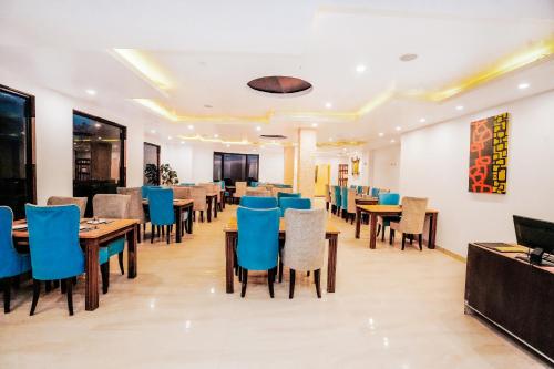 a dining room with tables and blue chairs at Himalayan Mountain and Valley View - Garden with bonefire - Ample Parking - Luxury Balcony rooms -by Aachman Stays!! Mashobra in Shimla