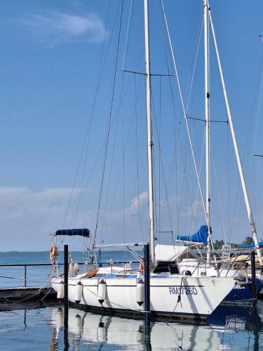 a white sailboat docked at a dock in the water at Cavallino House Boat in Cavallino-Treporti