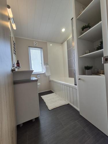 a bathroom with a tub and a sink and a toilet at The Blue Lagoon 2 bedroom lodge with hot tub in Walton-on-the-Naze