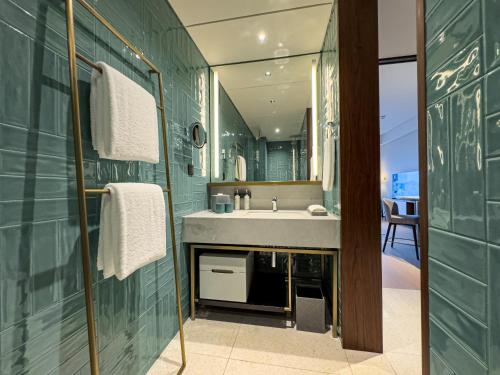 a bathroom with a sink and a green wall at New World Guangzhou Hotel-- FREE Canton Fair Shuttle Bus in Guangzhou