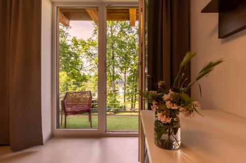 an open door to a patio with a vase of flowers at Vranovská pláž - Holiday park in Vranov nad Dyjí