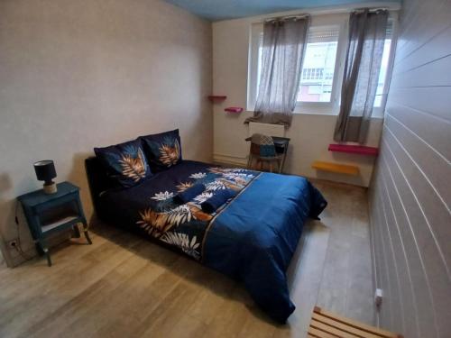 une chambre avec un lit bleu et une fenêtre dans l'établissement Superbe appartement 3 chambres, à Dijon