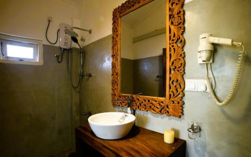 a bathroom with a sink and a mirror at Magnolia House Mirissa in Mirissa